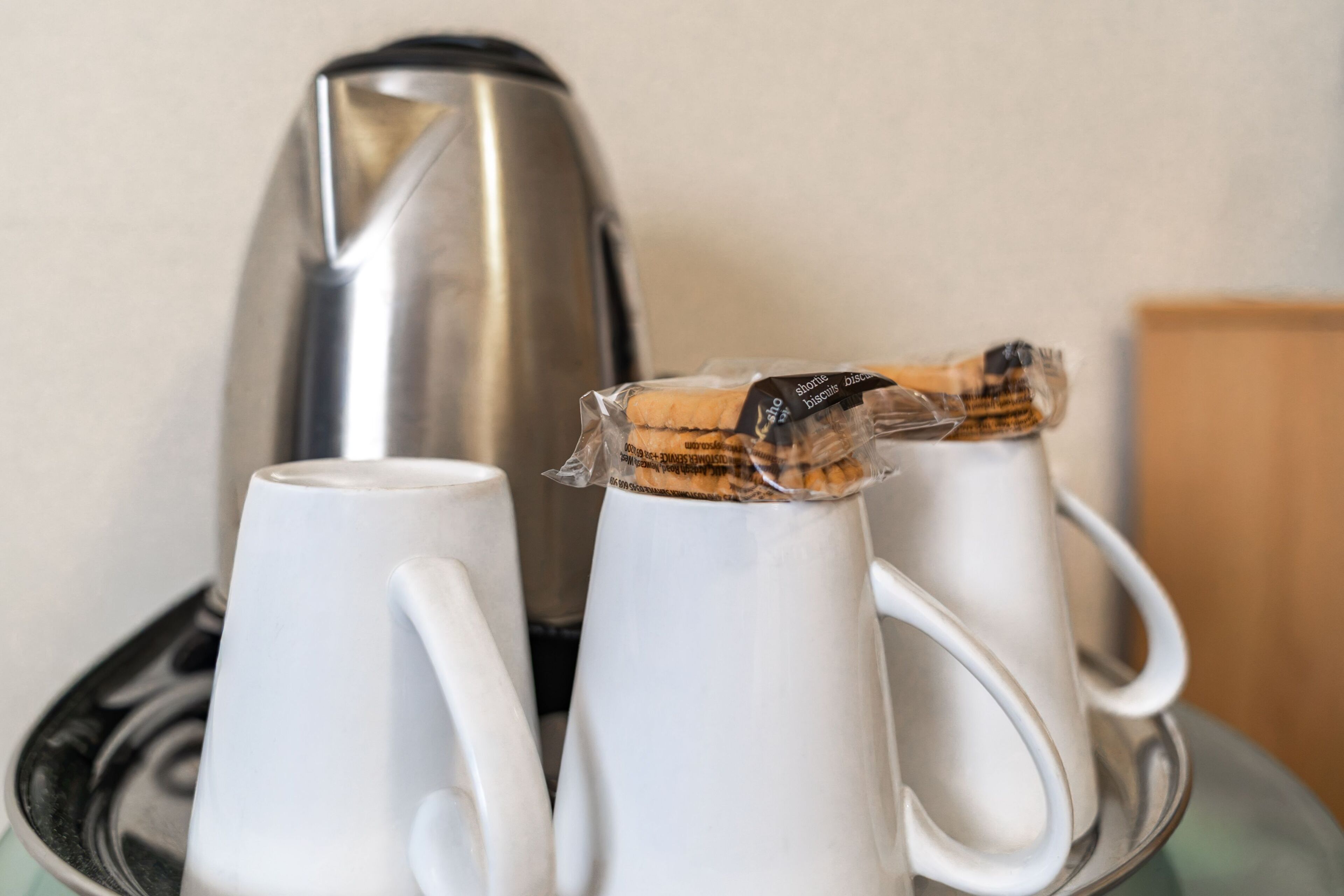 Two white mugs with cork stoppers on a tray.