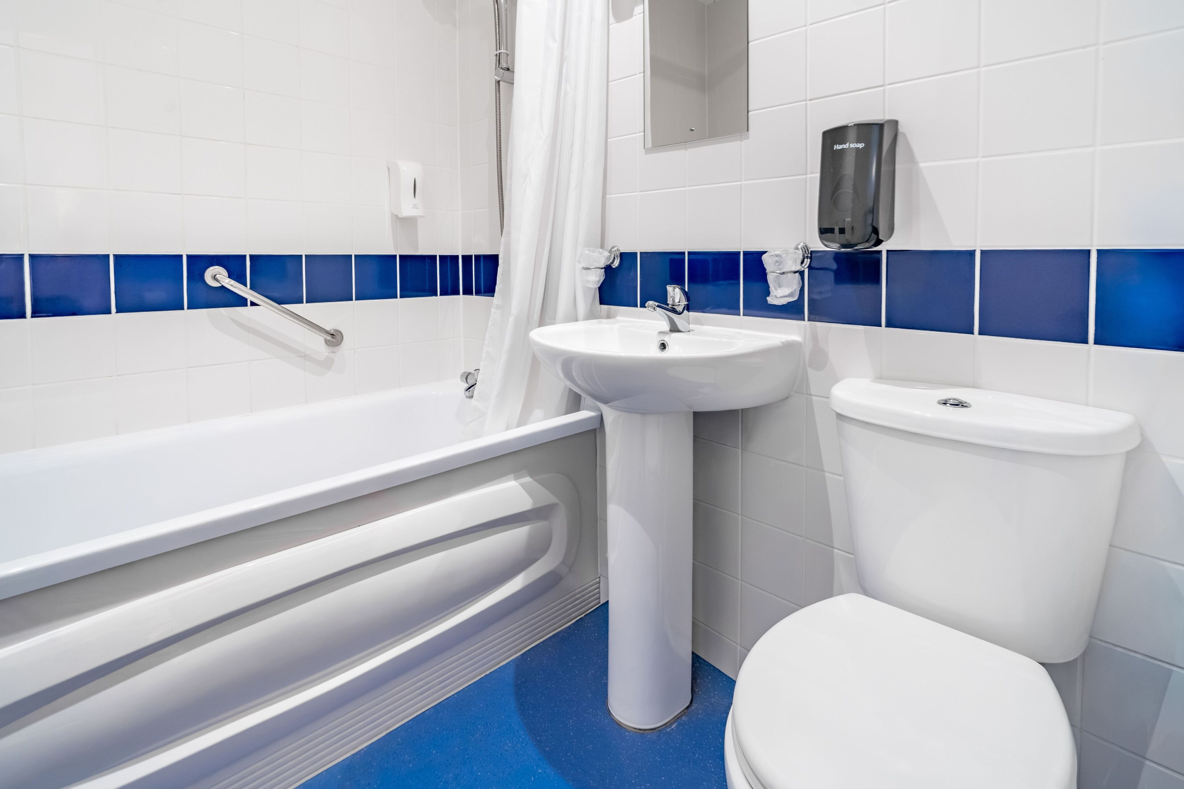 A bathroom with a bathtub, a sink, and a toilet.