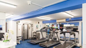 Un gimnasio con cintas de correr, elípticas y máquinas de pesas.