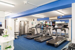 Un gimnasio con cintas de correr, elípticas y máquinas de pesas.