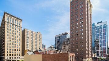 A cityscape with multiple high-rise buildings, including a mix of older brick structures and modern glass facades.
