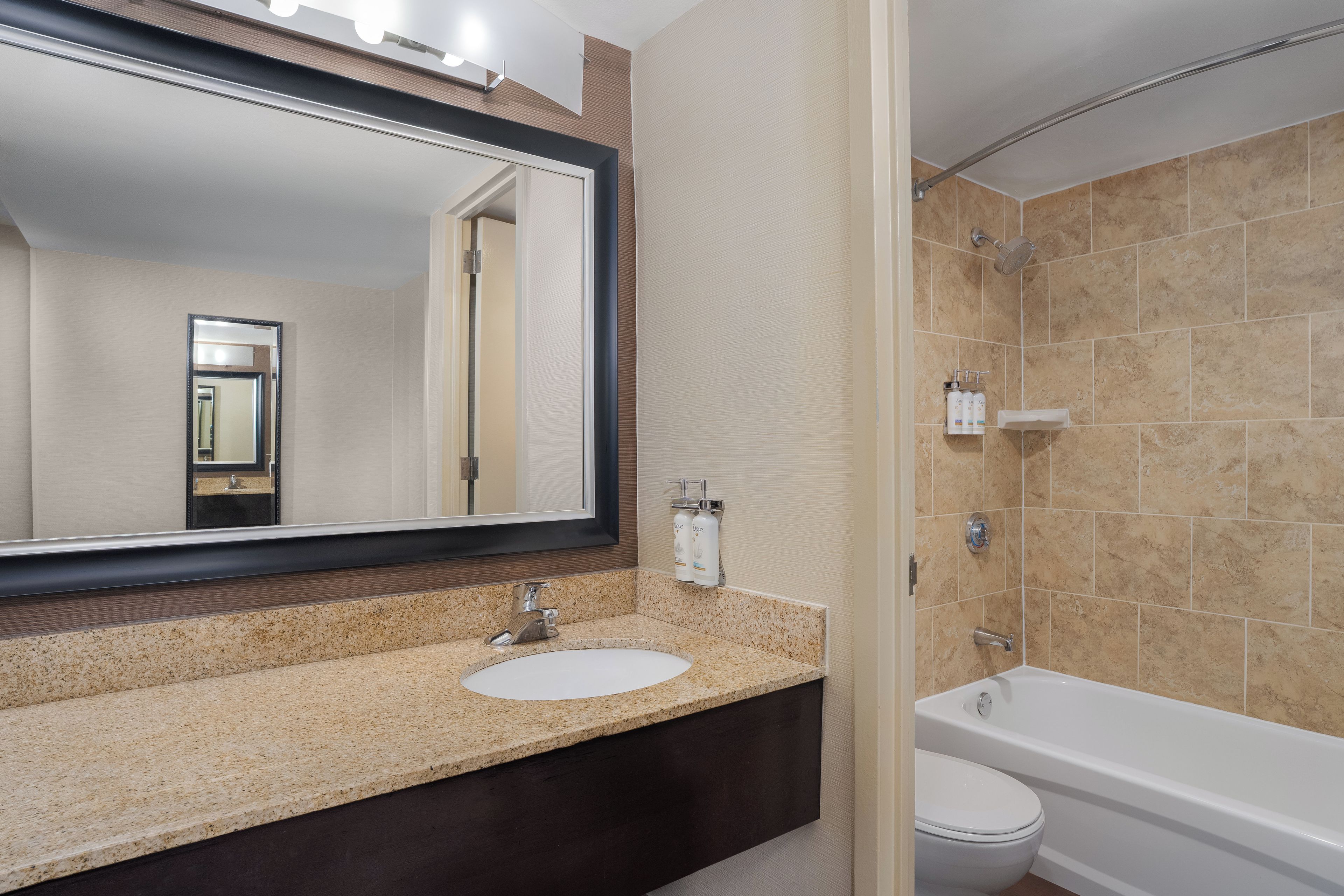 Une salle de bain équipée d’un lavabo, d’un miroir, de toilettes et d’une baignoire.