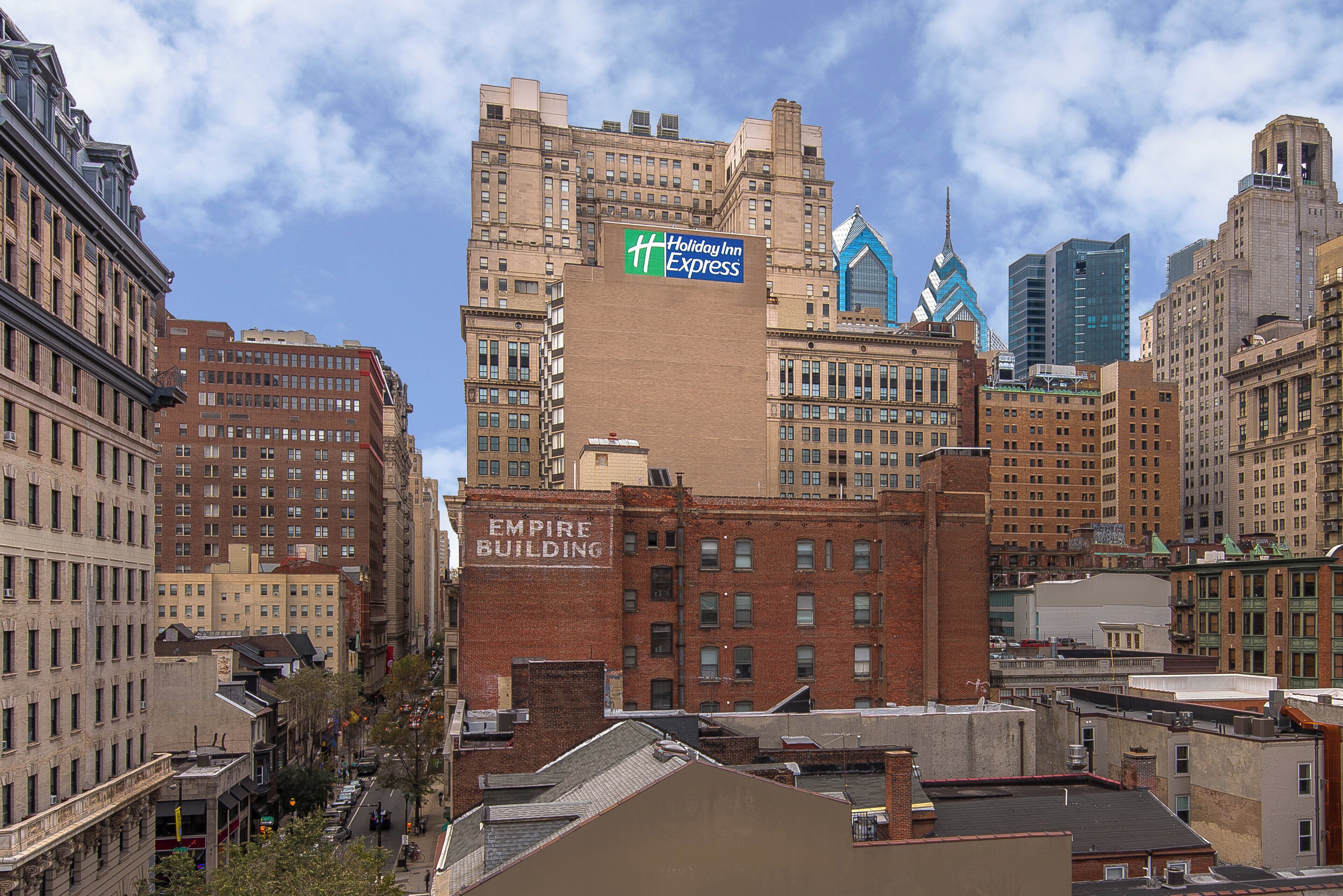 A cityscape with a prominent building featuring a Holiday Inn Express sign.