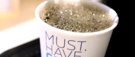 Una taza de café sobre una bandeja negra con el texto 'MUST HAVE COFFEE EXPRESS'.