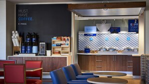 A modern coffee shop with seating, a coffee station, and a kitchen area. - Holiday Inn Express Philadelphia-Midtown by IHG (Philadelphia)