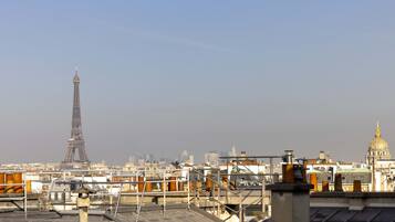 Une terrasse offrant une vue sur la Tour Eiffel et sur un dôme doré au loin.