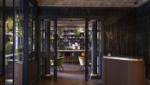 A reception area with a marble wall, a reception desk, and a seating area with chairs.
