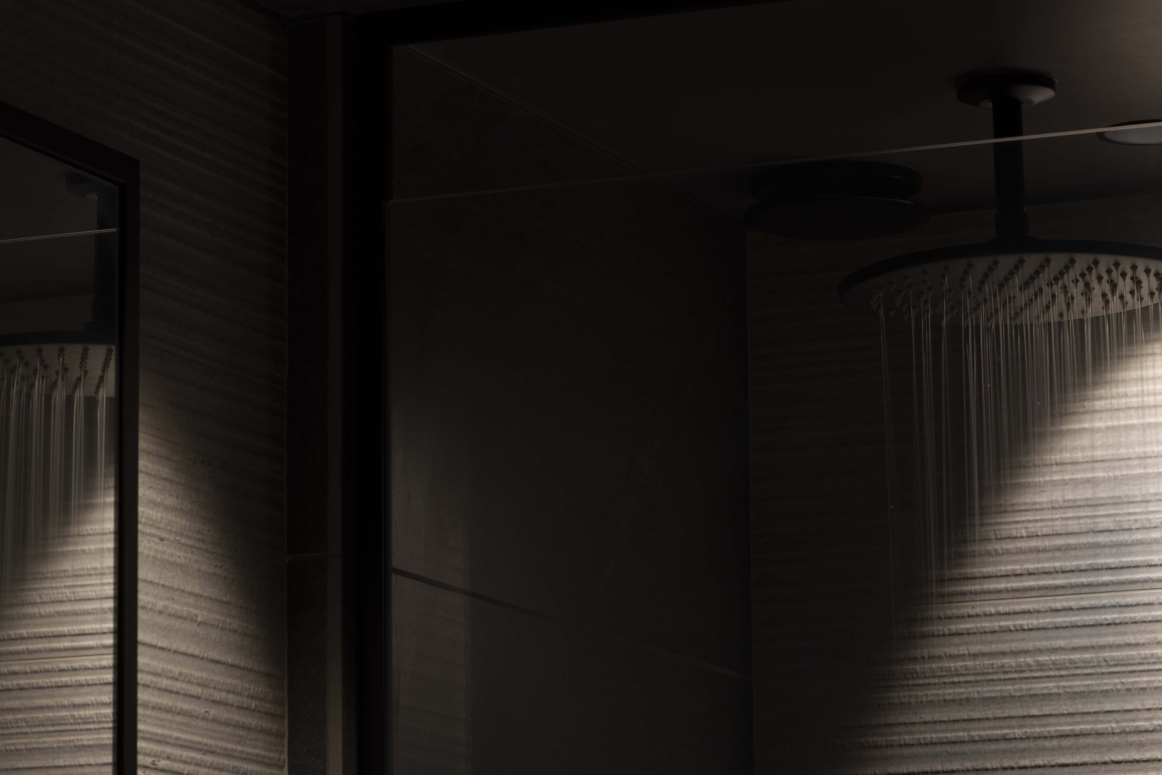 A modern interior with a textured wall and a cylindrical light fixture.