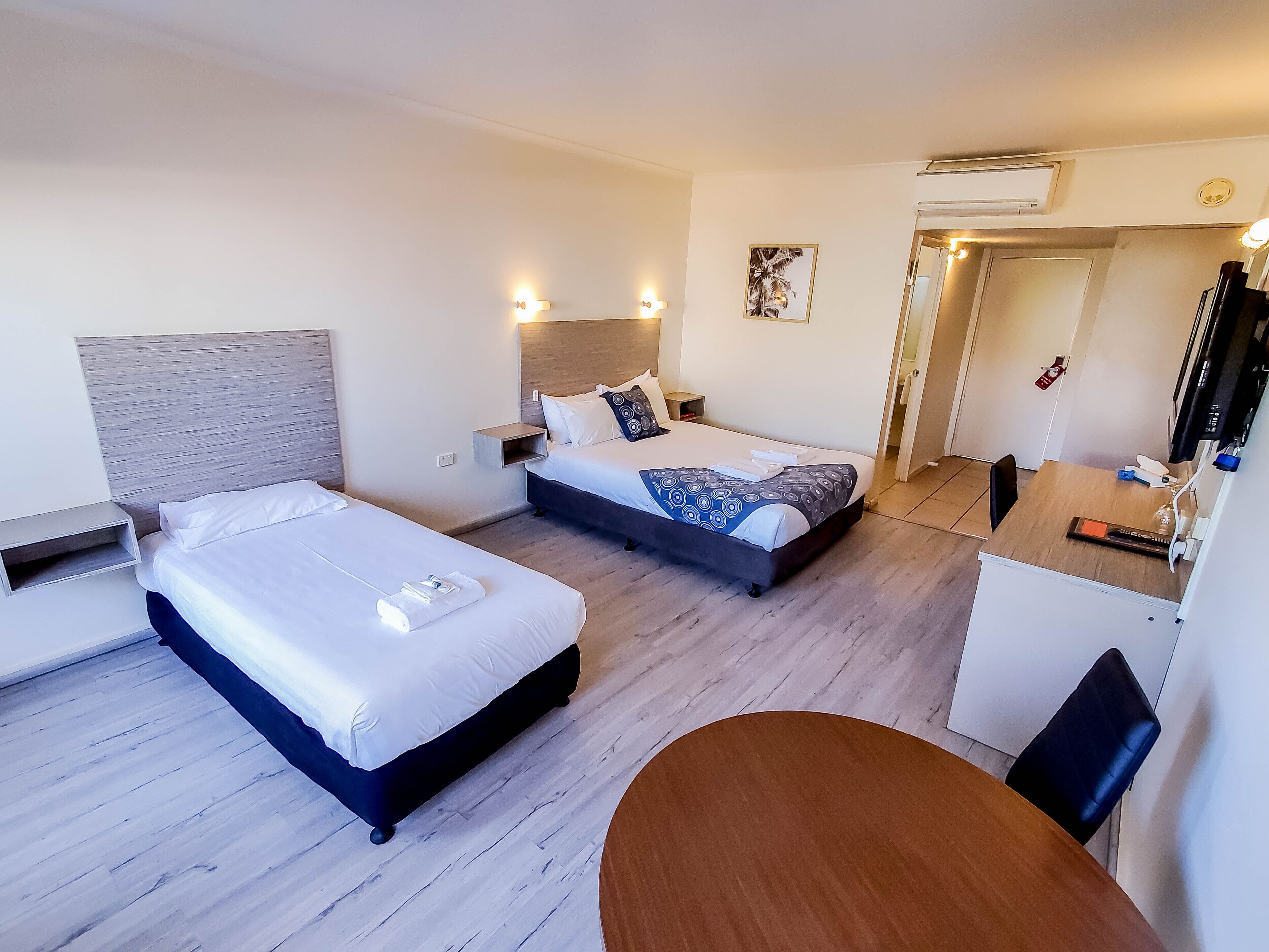 Una habitación de hotel con dos camas, un escritorio y una silla.