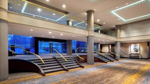 A spacious lobby with a grand staircase, large pillars, and a high ceiling with recessed lighting. - The Westin Waltham-Boston (Waltham)