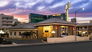 A hotel with a prominent MGM Grand sign in the background, a well-lit entrance, and a parking area. - Days Inn by Wyndham Las Vegas Airport Near the Strip (Las Vegas)