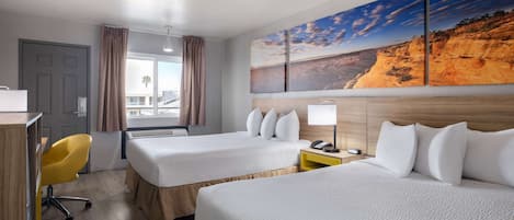 Habitación de hotel con dos camas, un escritorio, una silla, una ventana con cortinas y un cuadro grande con un paisaje.