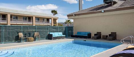 A pool area with lounge chairs and a sign for Days Inn by Wyndham.