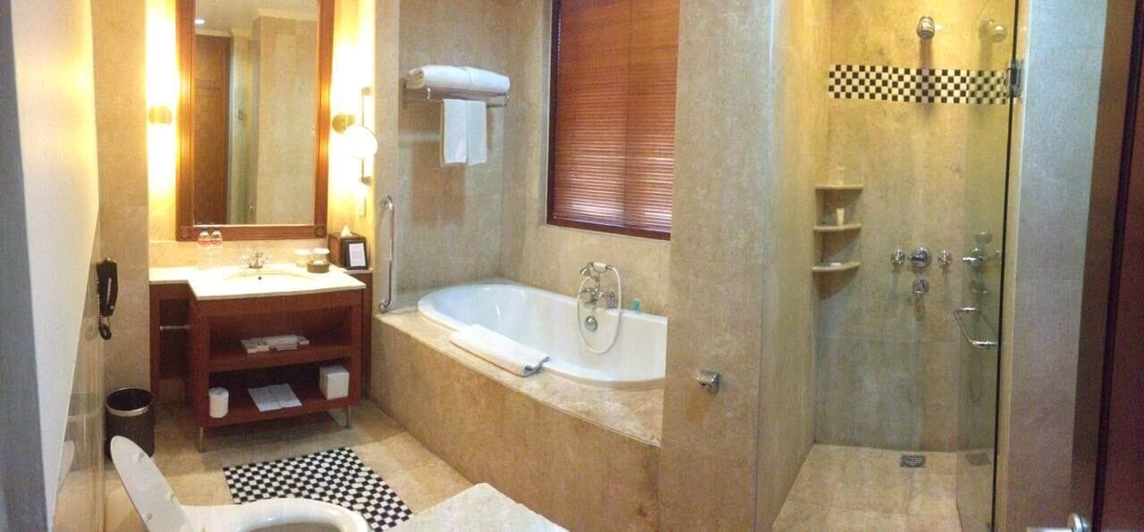A bathroom with a sink, mirror, bathtub, toilet, and shower.