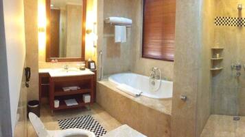 A bathroom with a sink, mirror, bathtub, toilet, and shower.