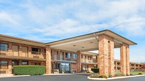 A multi-story brick building with a covered entrance and balconies. - Days Inn by Wyndham New Market/I-81 (New Market)