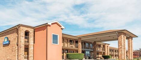A Days Inn with a brick facade, a covered entrance, and a parking lot.