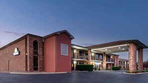 A hotel with a brick facade, a Day's Inn sign, and a covered parking area. - Days Inn by Wyndham New Market/I-81 (New Market)