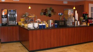 A buffet counter with various food items, a coffee machine, and a microwave. - Days Inn by Wyndham New Market/I-81 (New Market)