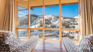 Una habitación con un ventanal que ofrece vistas a un paisaje montañoso cubierto de nieve.