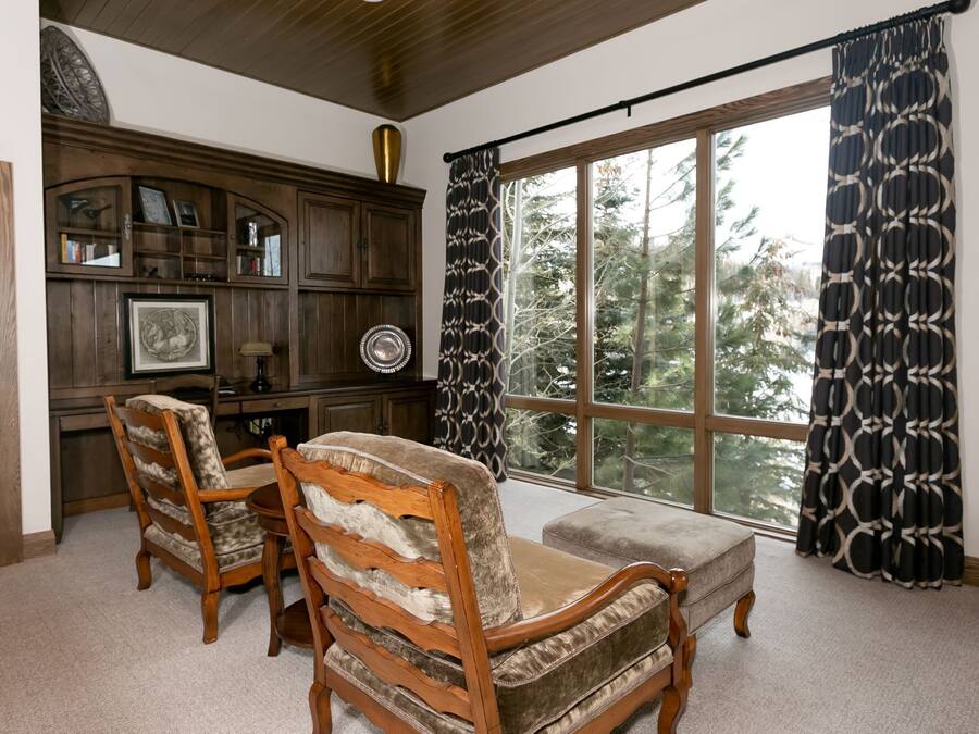 Una habitación con un ventanal grande, muebles de madera y un armario empotrado.