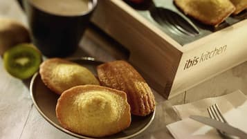 A plate of pastries, a cup of coffee, and a wooden box labeled 'ibis kitchen'.
