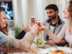 A group of people toasting with beer glasses at a dining table with food and a salad bowl. - ibis Epinay sur seine Gennevilliers (Epinay-sur-Seine)
