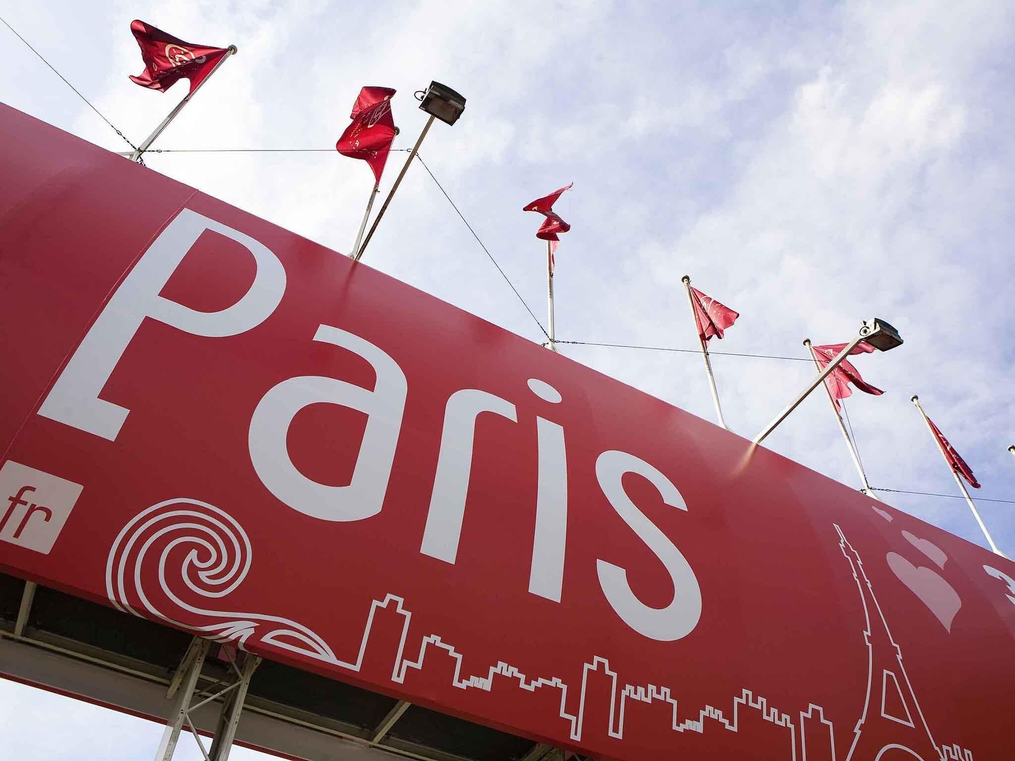 A large red sign with 'Paris' written on it, featuring the Eiffel Tower and other landmarks.