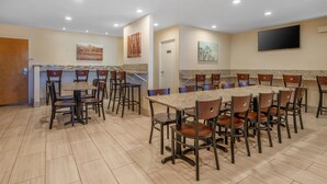 A conference room with a long table and chairs, a TV mounted on the wall, and artwork on the walls. - Best Western Plus Inn of Hayward (Hayward)