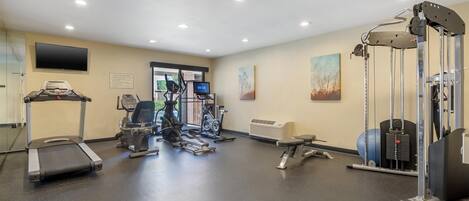 A gym with treadmills, elliptical machines, and weightlifting equipment.