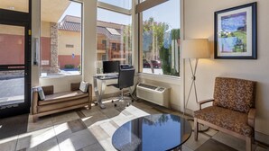 A hotel lobby with a sofa, a desk, a computer, a chair, and a table. - Best Western Plus Inn of Hayward (Hayward)