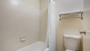 A bathroom with a bathtub, toilet, and a shower curtain.