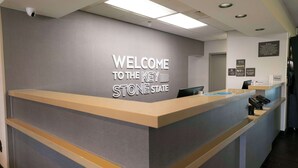 Taulell de recepció amb un cartell que diu 'Welcome to the Key Stone State', un telèfon de taula, un ordinador i una càmera de seguretat.