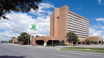 A Holiday Inn Express hotel with a brick facade, a large parking garage, and a clear sky.