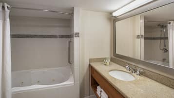 Une salle de bain avec une baignoire, un lavabo et un miroir.