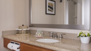A bathroom with a sink, mirror, towel rack, and a framed picture on the wall. - Holiday Inn Winnipeg South by IHG (Winnipeg)