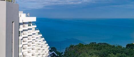 Un hotel moderno con varios balcones que dan a vistas costeras.