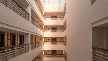 A multi-level atrium with a glass ceiling, multiple balconies, and a central open space.