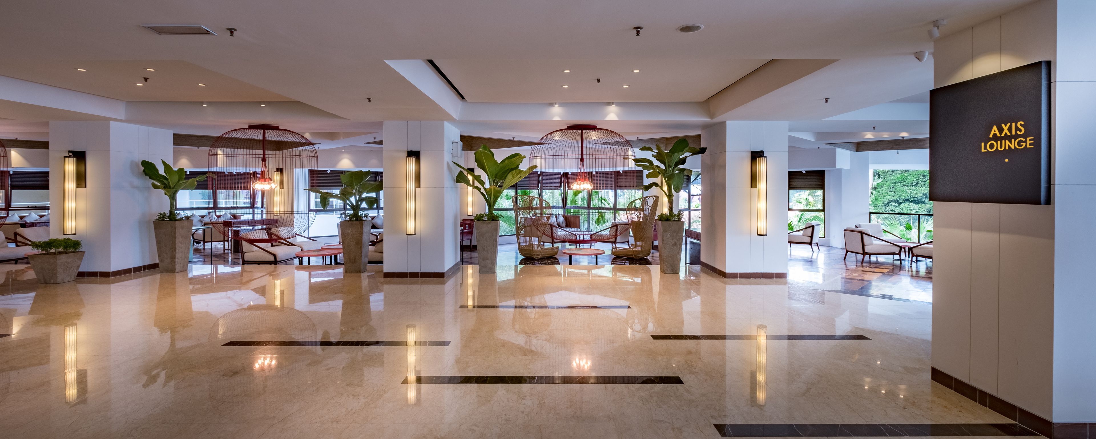A spacious lobby with modern furniture, large windows, and a sign reading "AXIS LOUNGE".