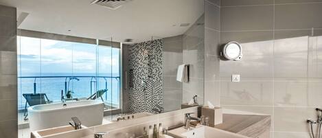 A modern bathroom with dual sinks, a large mirror, and a shower.
