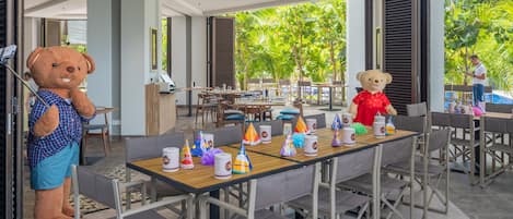 Comedor con una gran mesa dispuesta para una celebración, rodeada de sillas.