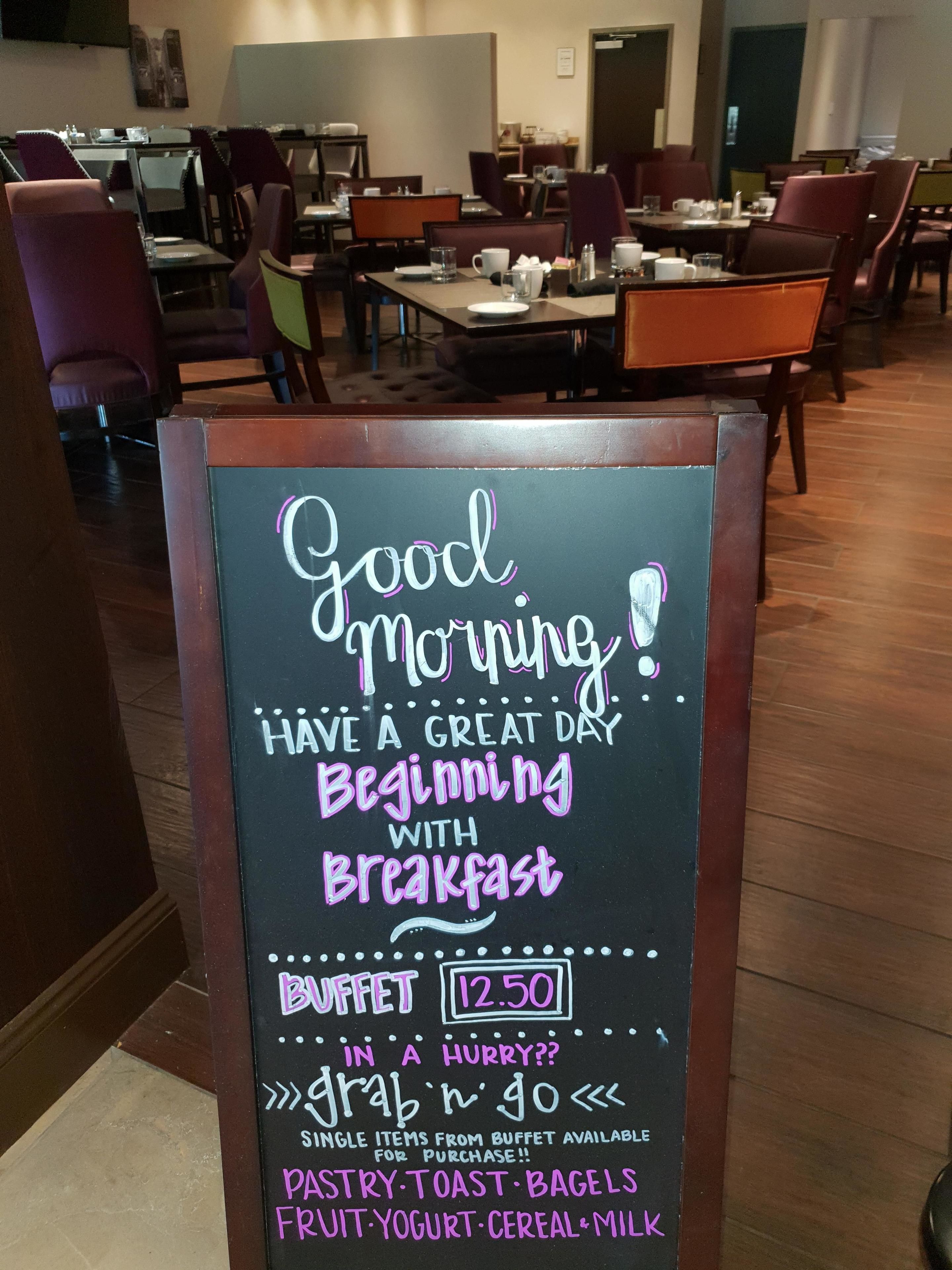 A sign in a restaurant with a breakfast menu and prices.