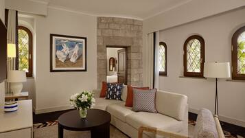 A living room with a sofa, a coffee table, a lamp, and a painting on the wall.