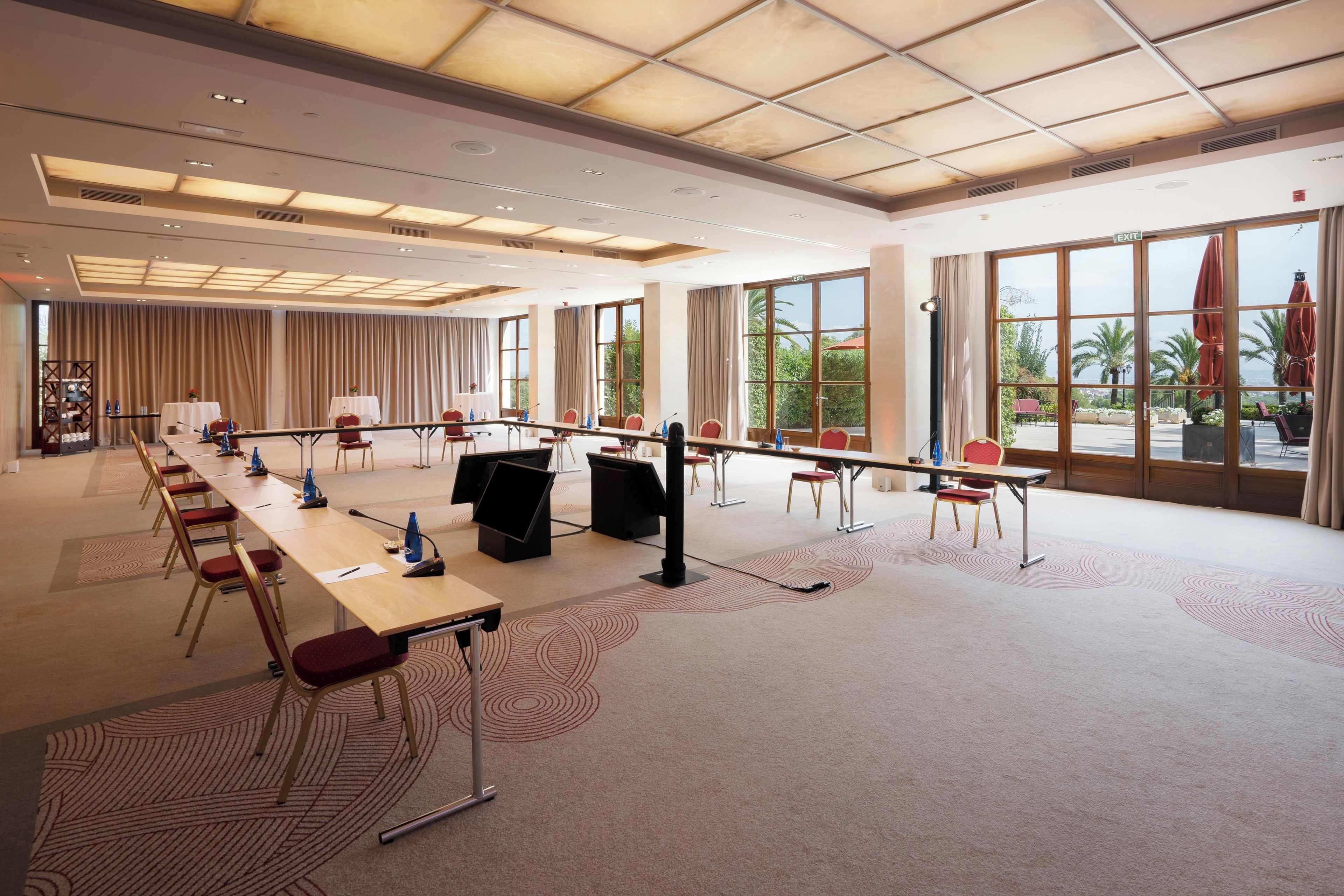 Un salón de conferencias con una larga mesa, sillas y un ventanal con vistas.
