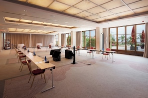 Una sala conferenze con un lungo tavolo, sedie e un'ampia finestra che offre una vista.