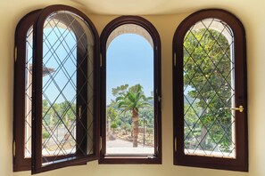 Une pièce dotée de trois fenêtres en arc de cercle, chacune ornée d’une grille métallique.