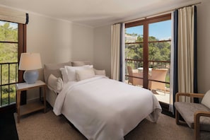 A hotel room with a bed, a nightstand, a lamp, a chair, and a view of the outdoors. - Castillo Hotel Son Vida, a Luxury Collection Hotel, Mallorca (Palma de Mallorca)