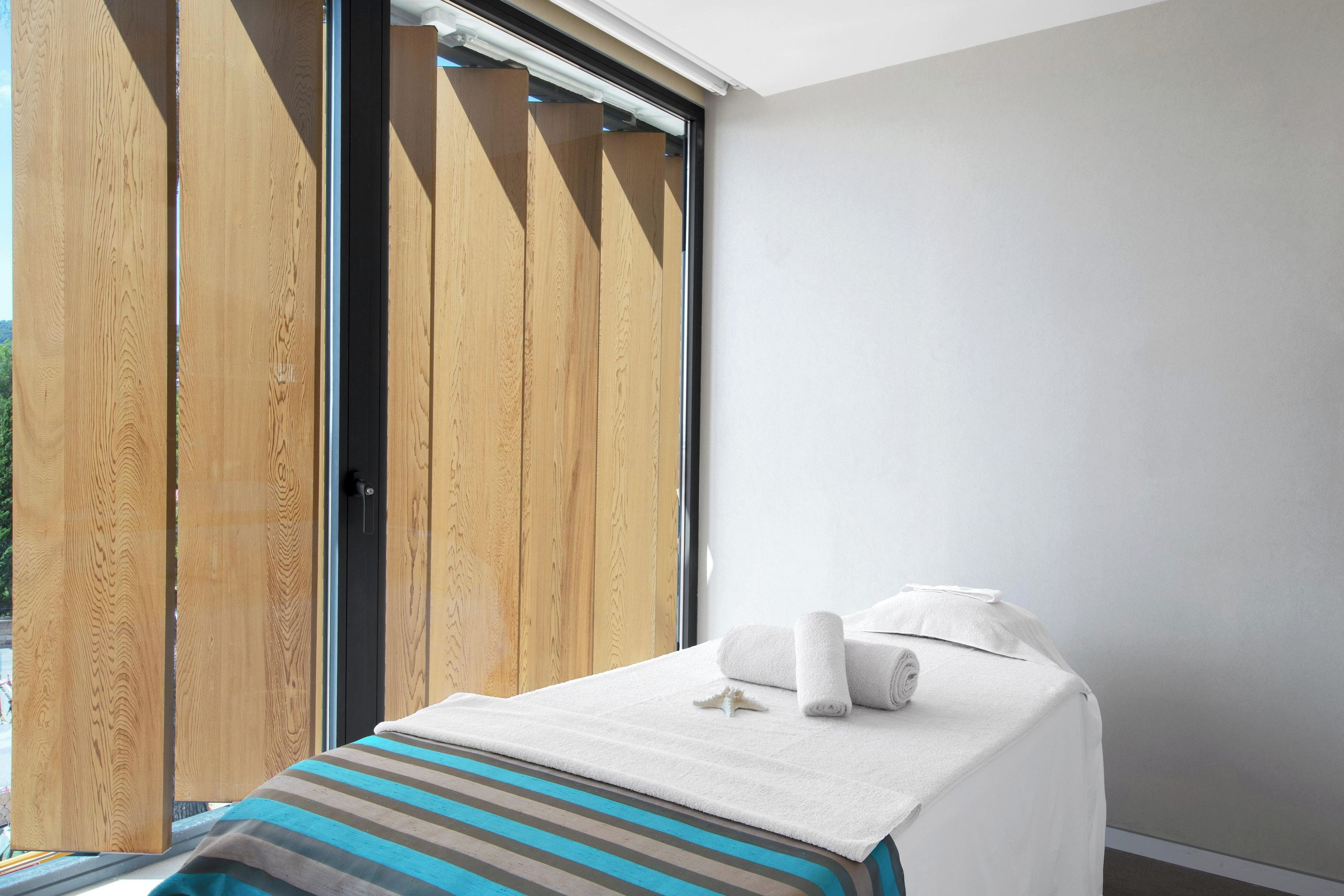 A room with a bed, a window, and a wooden door.