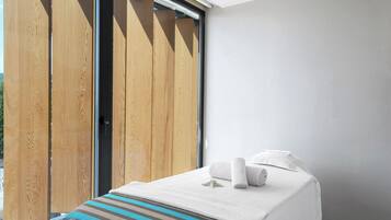 A room with a bed, a window, and a wooden door.