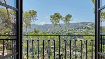 A balcony with a view of a mountainous landscape and trees.